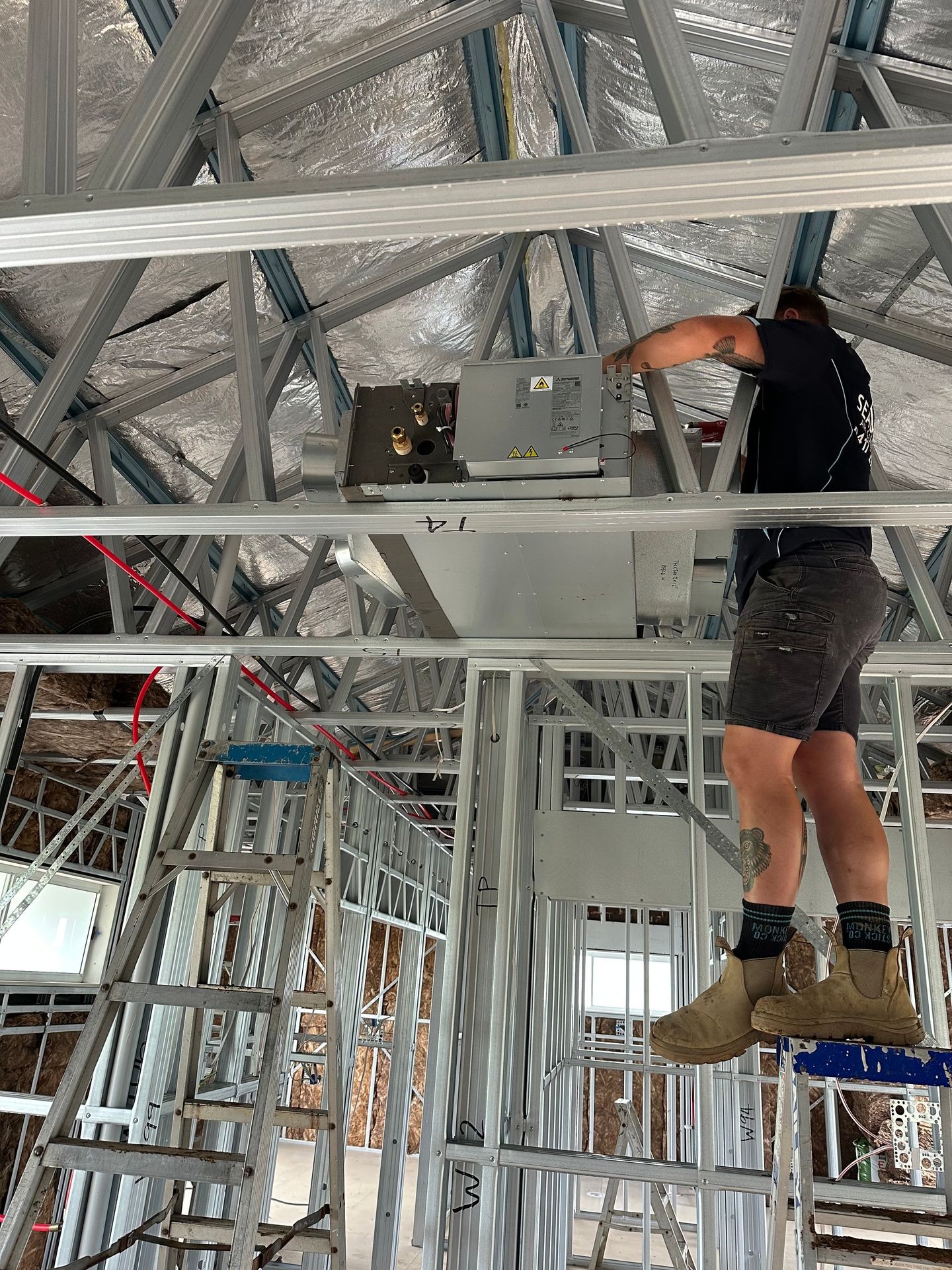 Air conditioning technician installs a ducted AC system
